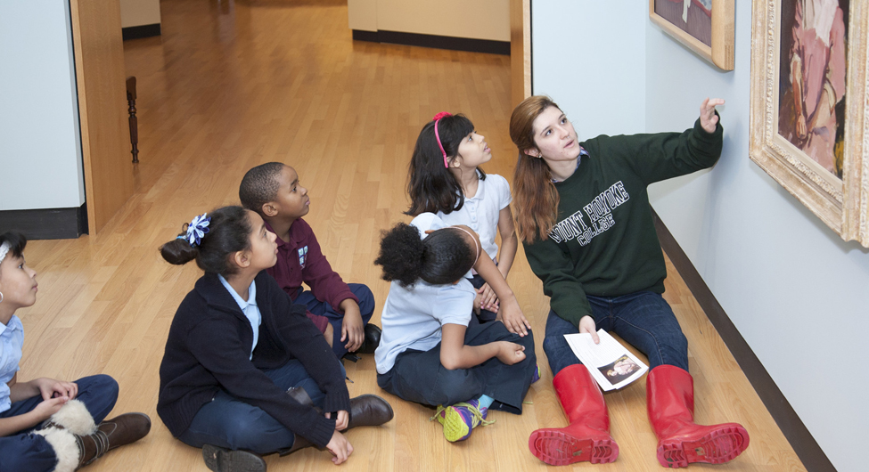 Mount Holyoke student volunteer guides a close-looking activity with elementary students
