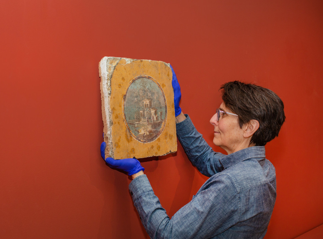 Preparator Ethel Poindexter with a fresco, March 2024