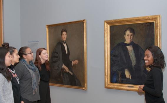 Student tour guides discuss portraits of Mary Woolley