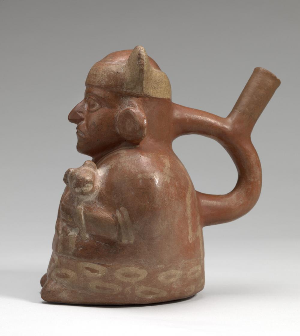 Moche, Stirrup-spouted vessel in form of a figure holding a feline Moche, Stirrup-spouted vessel in form of a figure holding a feline