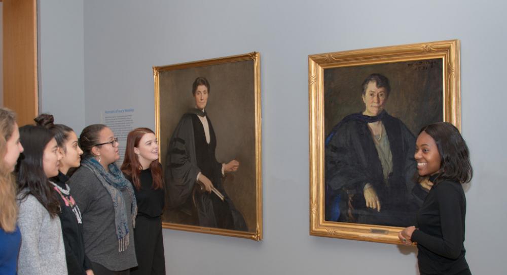 Student tour guides discuss portraits of Mary Woolley