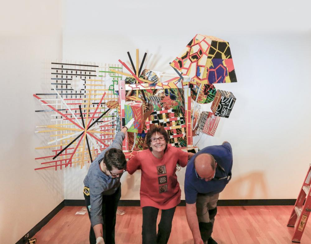 Bob Riddle, Jacqueline Finnegan, and Linda Best take a bow after completing the installation of a Judy Pfaff sculpture Bob Riddle, Jacqueline Finnegan, and Linda Best take a bow after completing the installation of a Judy Pfaff sculpture