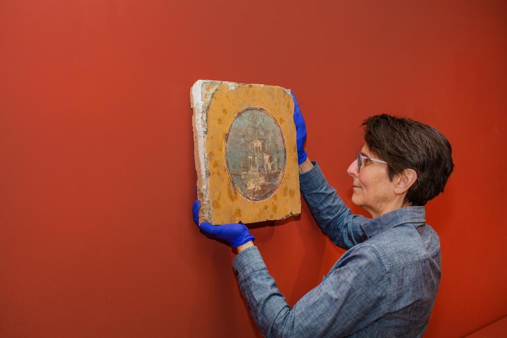 Preparator Ethel Poindexter with a fresco, March 2024 Preparator Ethel Poindexter with a fresco, March 2024