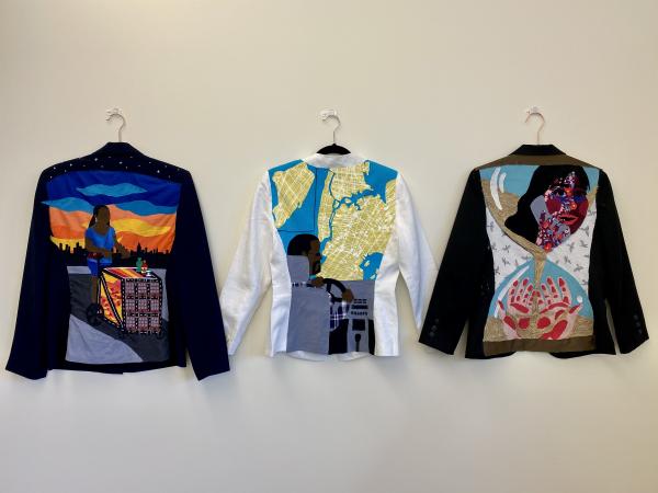 Jennifer Villa ’21, "Upon my back" series overview (2021). Fabric on blazers. 26 x18 in. The backs of 3 decorated blazers hung side by side.