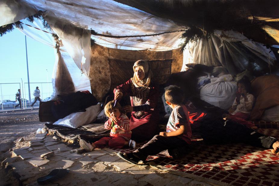 Lynsey Addario (American, b. 1973), October 22, 2013. Iman Zenglo, 30, sat with her five children in their tent at a squatters camp outside of the Kilis refugee camp on the Turkish side of the border with Syria (#11 from the series Syria’s Refugees, 2013 