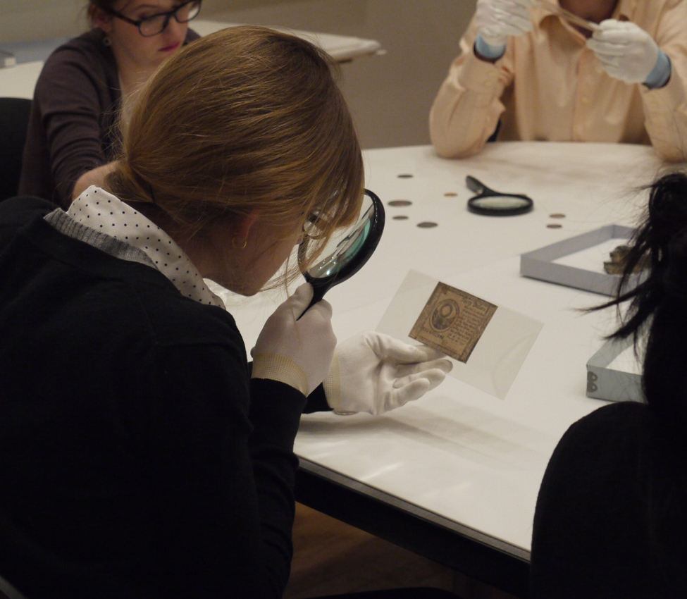 Students in History of Money, Spring 2024, Professor of History Desmond Fitz-Gibbon and students , Students examine various forms of money from the Art Museum and Skinner Museum collections