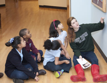 Mount Holyoke student volunteer guides a close-looking activity with elementary students
