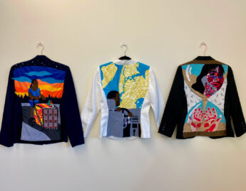 The backs of 3 decorated blazers hung side by side.