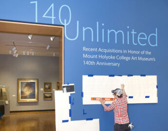 Museum Preparator Jacqueline Finnegan installs vinyl