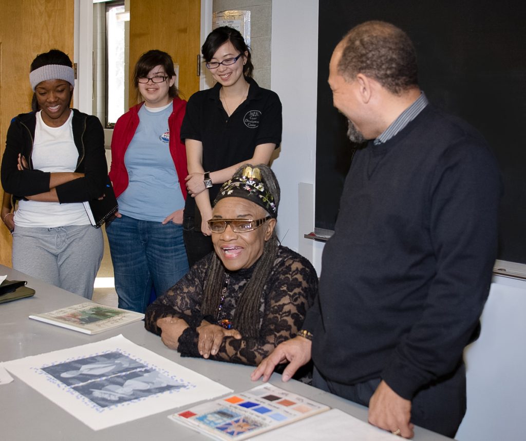 People gathered around a table looking at a print