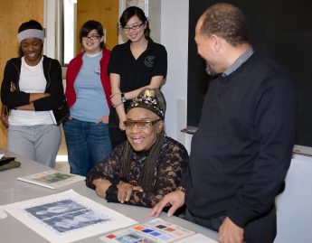 People gathered around a table looking at a print